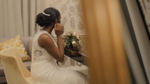 A bride looks into a mirror while adjusting her earring