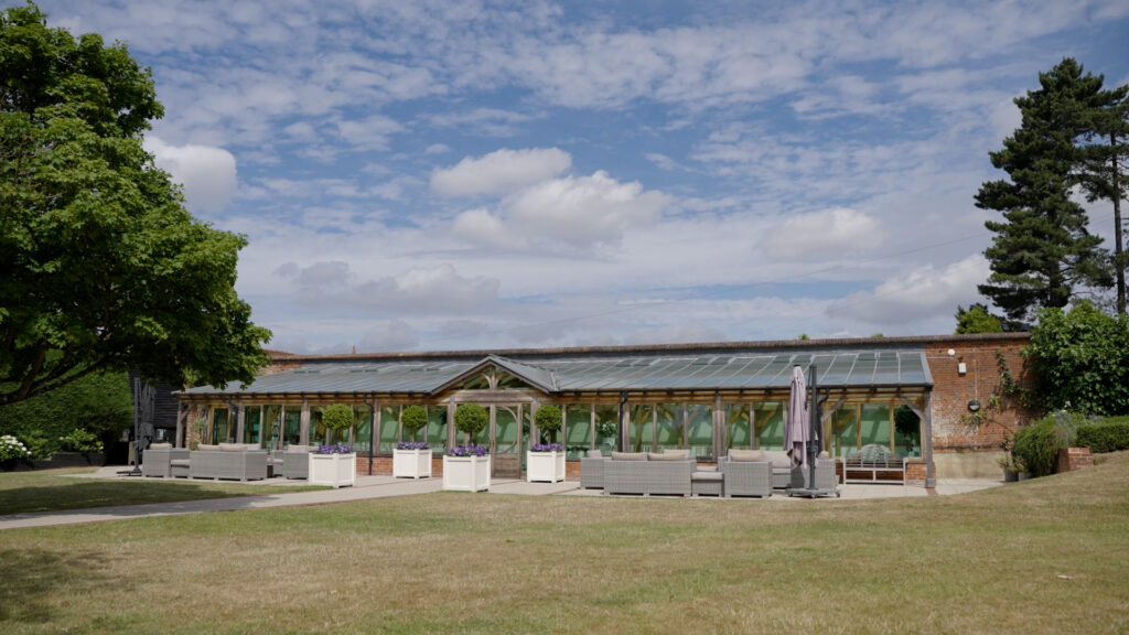 Gaynes park orangery sits empty with outdoor seating on the patio and the grass infront of it